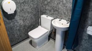 ein Badezimmer mit weißer Toilette und Waschbecken in der Unterkunft 3 Peaks Bunkroom in Settle