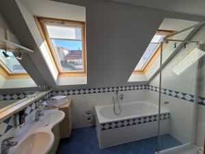 a bathroom with a sink and a bath tub at Hotel Restaurant Der Greif in Leoben +46 photos