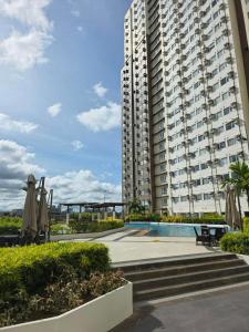 a large apartment building with a pool in front of it at Avida Tower 1, Unit 2003 - Chi's Place in Cagayan de Oro