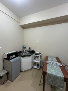 a small kitchen with a table and a sink at Avida Tower 1, Unit 2003 - Chi's Place in Cagayan de Oro