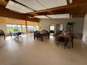 a large room with tables and chairs and windows at Þórsheimili - Rooms in Vestmannaeyjar