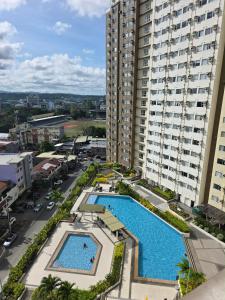 an aerial view of two swimming pools in a building at Avida Tower 1, Unit 2003 - Chi's Place in Cagayan de Oro