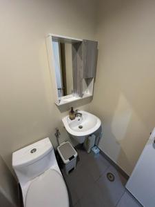 a bathroom with a white toilet and a sink at Avida Tower 1, Unit 2003 - Chi's Place in Cagayan de Oro +2 photos