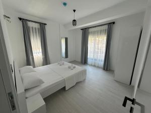 a white room with a bed and two windows at Doğan Homes Likya in Demre