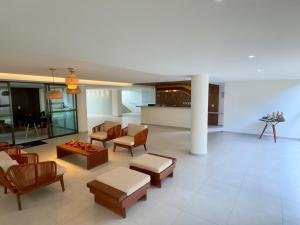 a living room with couches and chairs and a table at Flat Garden Açores Tamandaré Jardim Privativo Piscina Infinity in Tamandaré
