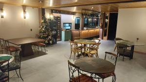 a restaurant with tables and chairs and a christmas tree at Sonnen Schein Chalés in São Martinho