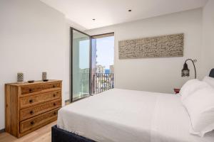 a white bedroom with a bed and a window at Rotolo Roof 21 5C in Catania