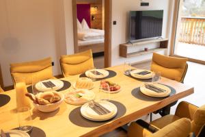 een houten tafel met borden en kommen met eten erop bij dein Dahoam Boutique Appartements in Gröbming