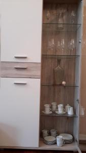 a cabinet with cups and plates and a vase at Ferienwohnung Am Korretsberg in Kruft +30 photos