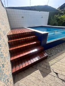 a set of stairs next to a swimming pool at Casa Verde Bertioga, um espaço cheio de charme com três praias - Indaiá, Pedra Selada e Riviera de São Lourenço para visitar a pé! in Bertioga