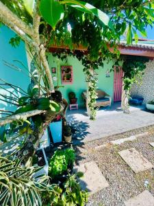 a room with a tree and a bench in front of a building at Casa Verde Bertioga, um espaço cheio de charme com três praias - Indaiá, Pedra Selada e Riviera de São Lourenço para visitar a pé! in Bertioga
