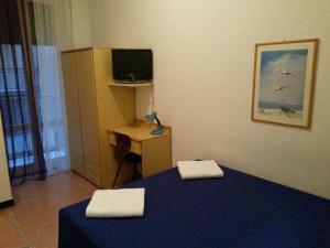 Habitación con 2 camas y escritorio con TV. en Hotel Bel Sit, en Rapallo