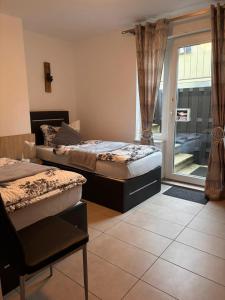 two beds in a room with a window at Am Dollespark in Bodenheim +15 photos