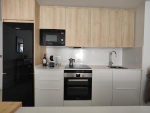 a kitchen with white cabinets and a black oven at La Mosa Sol in San Javier