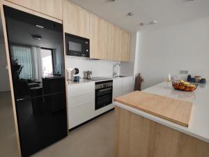 a kitchen with white cabinets and a black refrigerator at La Mosa Sol in San Javier
