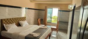 una camera da letto con un letto grande e una finestra di Sea side Residency a Māvalli Altre 19 foto