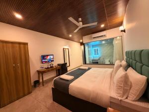 una camera da letto con un letto grande e una televisione di Orange Sky Inn a Canacona