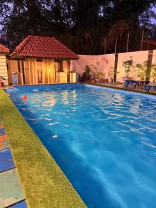 una piscina con una casa sullo sfondo di Orange Sky Inn a Canacona
