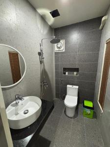 a bathroom with a sink and a toilet and a mirror at Tulip Elegant Riverside Hotel in Vang Vieng +96 photos