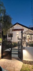 an open gate to a building with a sign on it at Cabañas Río in Huerta Grande +29 photos
