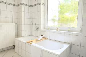a white bathroom with a tub and a sink at Hofgut Eveshausen - Dreiseitenhof - Spielscheune - Landidylle - Hofleben in Dommershausen +30 photos