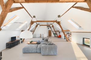 a living room with a blue couch and skylights at Stodola Rybojady in Rybojady