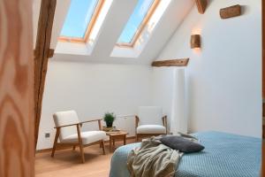 a bedroom with a bed and two chairs and a table at Stodola Rybojady in Rybojady