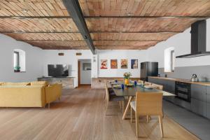 a kitchen and living room with a wooden ceiling at Stodola Rybojady in Rybojady