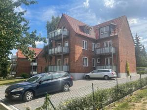 two cars parked in front of a brick building at Claras Gartenblick in Schwerin, Nähe Schloss, Hbf & Altstadt, ruhige zentrale Lage, kostenfreie Parkplätze in Schwerin