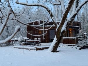 een hut in de sneeuw met een bank en een tafel bij Großzügiges Tiny House in Sumte