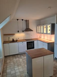 a kitchen with white cabinets and a counter top at Exclusive boende Suite 2 med 4 bäddar i stort sovrum varav 2 bäddar kan stänga om sig in Frederikshavn