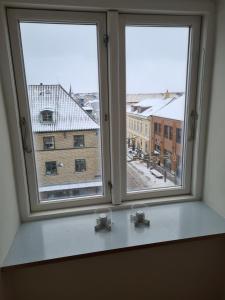 two windows with a view of a building at Exclusive boende Suite 2 med 4 bäddar i stort sovrum varav 2 bäddar kan stänga om sig in Frederikshavn