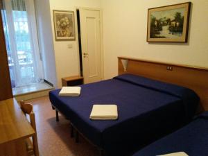 sypialnia z niebieskim łóżkiem i 2 ręcznikami w obiekcie Hotel Bel Sit w Rapallo