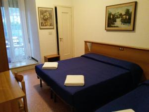 a bedroom with a blue bed with two towels on it at Hotel Bel Sit in Rapallo