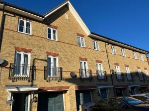 a brick building with balconies on the side of it at Chartsworth 4 Bedrooms Spacious House in Harold Wood