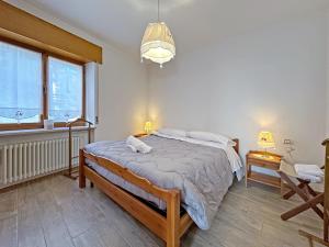 a bedroom with a bed and two windows at BBkey La cjase SOT LA STRETE in Arta Terme
