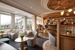 a restaurant with chairs and a bar with a view at Hotel Der Heinrichshof in Lagundo