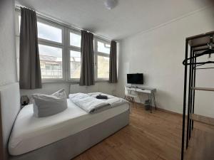 a bedroom with a bed and a desk in it at Pension BeOne in Trossingen