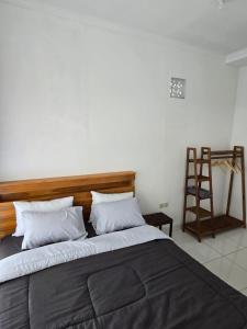 a bedroom with a bed with a wooden headboard and a ladder at Ina Guesthouse in Lovina