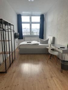 a bedroom with a bed and a desk and a window at Pension BeOne in Trossingen +16 photos