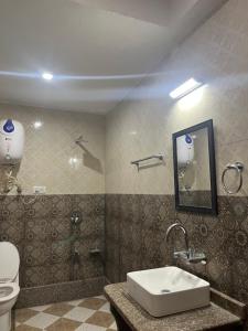 a bathroom with a sink and a toilet at Hotel Apex in Srinagar +5 photos