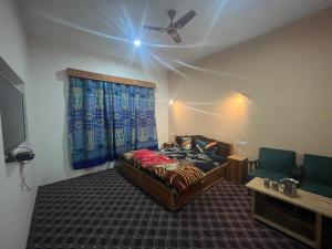 a bedroom with a bed and a ceiling fan at Hotel Apex in Srinagar