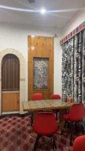 a conference room with a table and red chairs at Hotel Apex in Srinagar