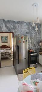 a kitchen with a stainless steel refrigerator and a bed at Pousada 48 Graus - Caldas do Jorro BA in Poço Redondo
