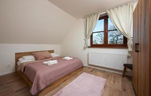 a bedroom with a bed with two towels on it at Hotel Tulipan in Tatranská Lomnica +65 photos
