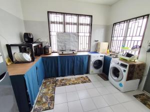una lavanderia con lavatrice e lavatrice di MAM Guesthouse Kota Tinggi a Kota Tinggi Altre 6 foto
