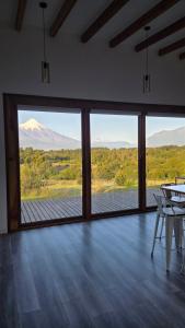 a room with large windows with a view of a mountain at Casa Vulkaan in Puerto Varas
