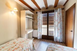 een kleine slaapkamer met een bed en een raam bij Encanto de Valderrobres in Valderrobres
