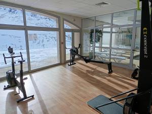 a gym with a treadmill and exercise equipment and windows at Hourquette in Bagnères-de-Bigorre