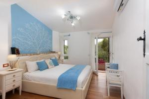 una camera da letto con un letto grande e una finestra di Villasimius - Villa Sofia a San Stèfano